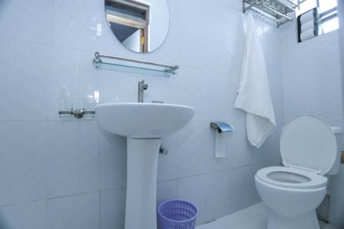 a white bathroom with a sink and a toilet at Meru modern living bnb 1bdr and 2bdr in Meru