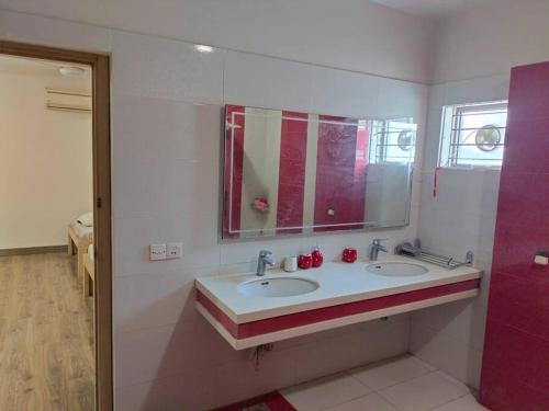 a bathroom with two sinks and a mirror at Entire Bungalow In Karachi in Karachi