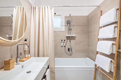 La salle de bains est pourvue d'une baignoire blanche et d'un lavabo. dans l'établissement Hotel Atlantic, à Lignano Sabbiadoro