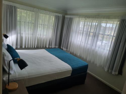 a bedroom with a large bed with white curtains at See Street Apartments by Kacys in Bargara