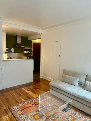 un salon avec un canapé et une cuisine dans l'établissement Cosy appartement Montmartre, à Paris