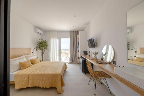 a bedroom with a bed and a sink and a mirror at Olive Vista Suites in Kastraki