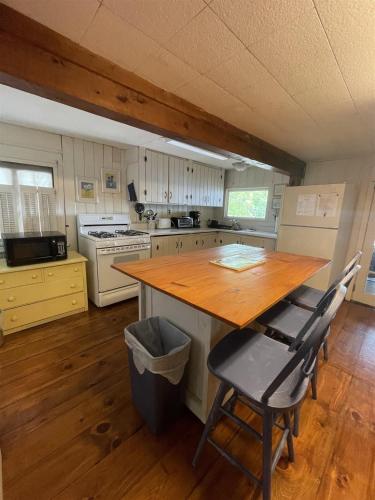 a kitchen with a wooden table and chairs in it at LITTLE SANDY-LIMIT 8 cottage in North Sebago