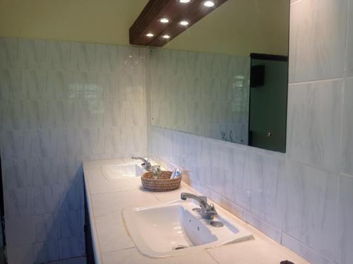 a bathroom with two sinks and a mirror at 2Livu Villas Watamu in Watamu