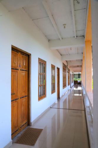 een lege hal van een gebouw met houten deuren bij Dulmini Holiday Resort in Anuradhapura
