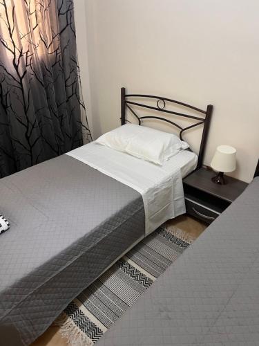 um quarto com uma cama com um cobertor preto e branco em Cozerea Apartment em Atenas