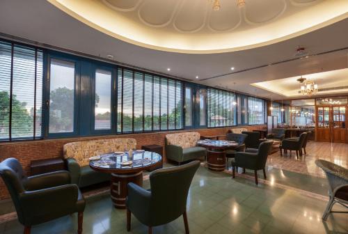 a restaurant with tables and chairs and windows at Namaste Dwaar - The Gateway to Rural India in Khatauli