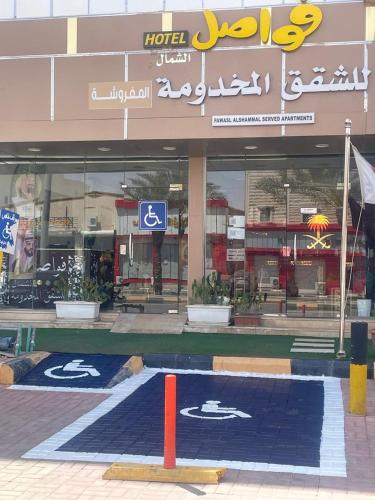 een winkel met een blauw tapijt voor een gebouw bij فواصل الشمال للشقق المخدومة in Rafha