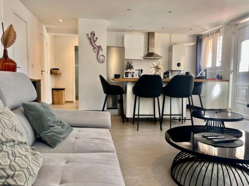 un salon et une cuisine avec un canapé et une table dans l'établissement Provence deux chambres & jardin, à Antibes
