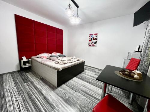 1 dormitorio con cama y pared roja en Pensiunea Liziera 1 en Buşteni