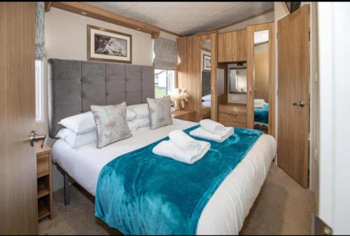 Beautiful 3-Bed Lodge in St Andrews في سانت أندروز: غرفة نوم بسرير كبير عليها مناشف