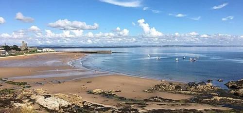 a beach with a group of boats in the water at Beautiful 3-Bed Lodge in St Andrews in St. Andrews