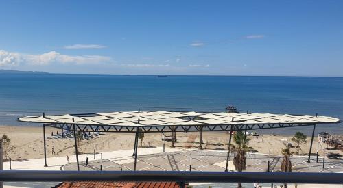 a view of a beach with a large white umbrella at Vila Tirona in Durrës