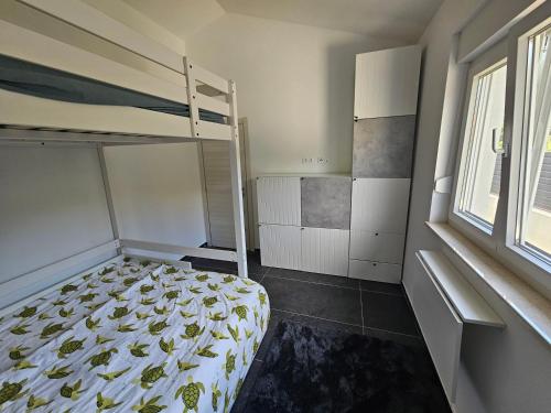 a small bedroom with a bunk bed and a window at Seaside Cottage Barbariga in Peroj