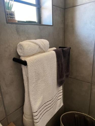 a bathroom with three towels on a towel rack at Kimberly Luxury Suites in Kimberley