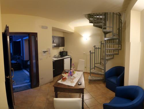 a living room with a kitchen and a spiral staircase at Cortile dei Sogni in Catania