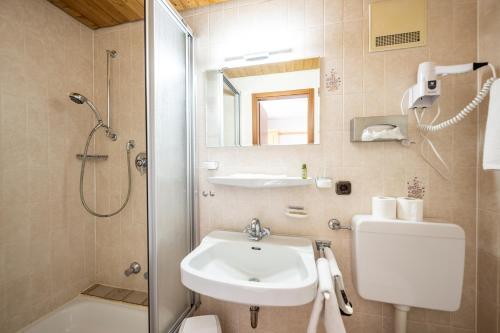 a bathroom with a sink and a shower and a toilet at Haus Widdersteinblick in Riezlern