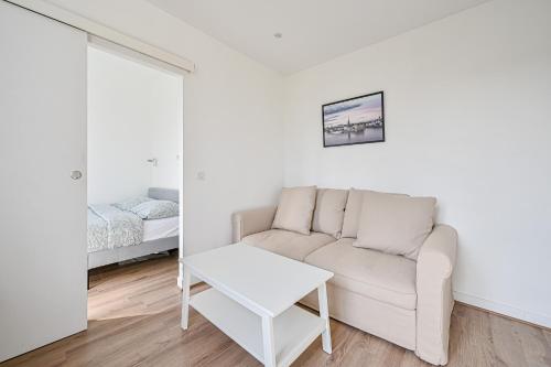 - un salon blanc avec un canapé et un lit dans l'établissement Appartement cosy rénové, proche métro Paris, à Maisons-Alfort