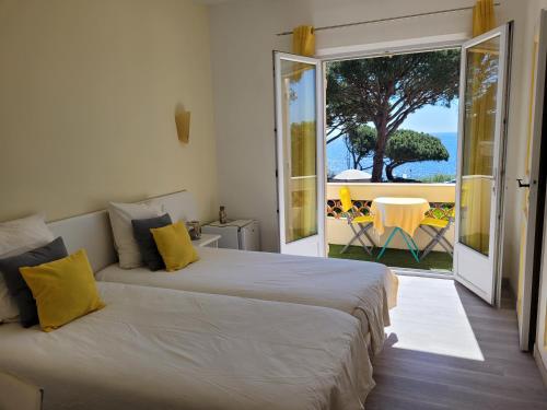 two beds in a room with a view of the ocean at Villa Esmeralda in Les Issambres