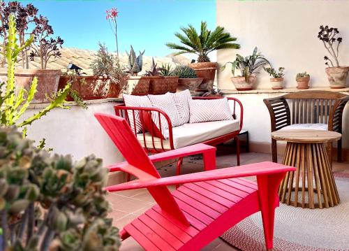 a red bench and a couch on a patio at Albaria in Birgi Vecchi