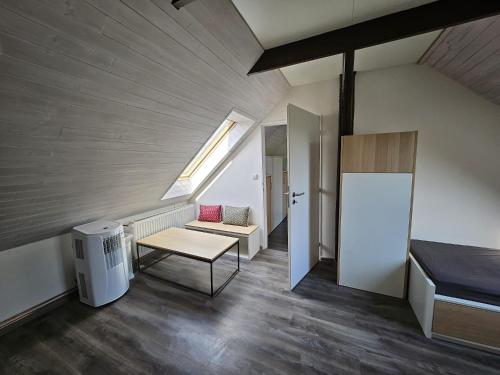 an attic room with a bench and a table at Apartmán YASNE in Ostrava