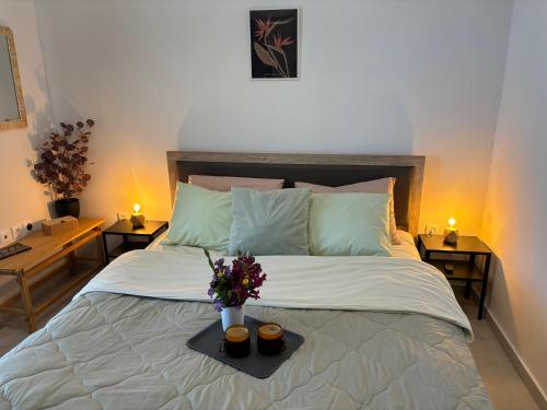 Un dormitorio con una cama y una bandeja con flores. en Anemar Lefkada, en Drymon