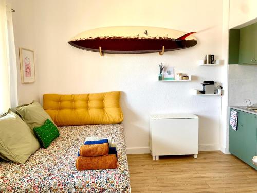 - un salon avec un canapé et une planche de surf sur le mur dans l'établissement COSY & SURF : Confort et vue Mer à Seignosse Le Penon, à Seignosse