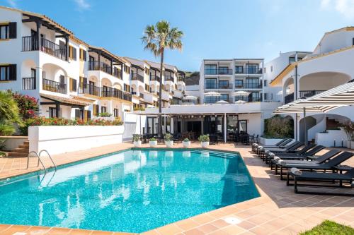a swimming pool in front of a building at Calallonga Hotel Menorca in Mahón