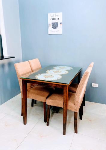a dining room table with chairs and a blue wall at Charming Duplex Apartment in Tagbilaran City