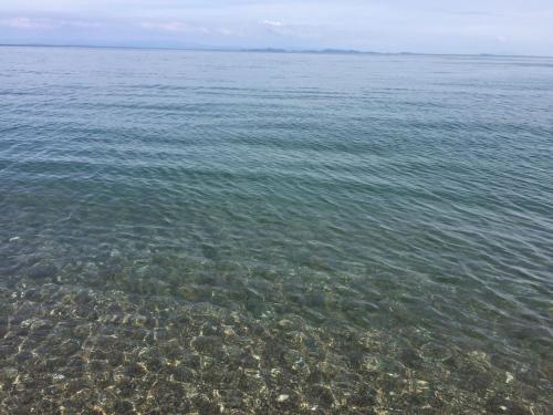a large body of water with rocks in the water at Assos Altın Hotel in Behramkale