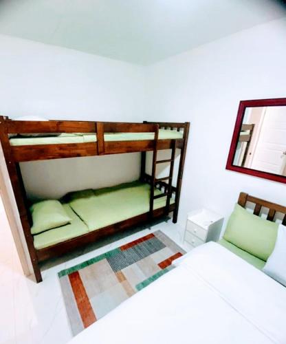 a bedroom with two bunk beds and a mirror at Charming Duplex Apartment in Tagbilaran City