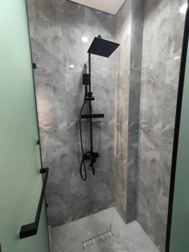 a shower in a bathroom with a stone wall at ЖК Prime Park in Shymkent