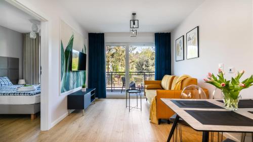 a living room with a couch and a table at JANTAR RESORT Apartamenty PIAMOLA in Jantar