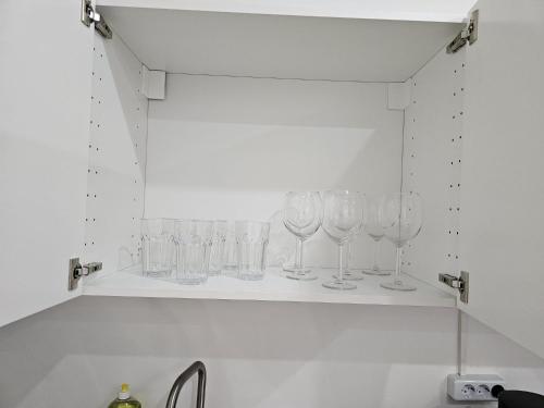 a row of wine glasses sitting on a shelf at SFN Home Stay in Bergisch Gladbach