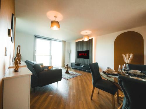 a living room with a table and chairs and a living room with at The Safari Suite Luxury Apartment Milton Keynes in Milton Keynes
