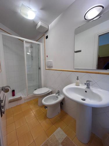 W łazience znajduje się umywalka, toaleta i lustro. w obiekcie Palazzo Verone w mieście Scala