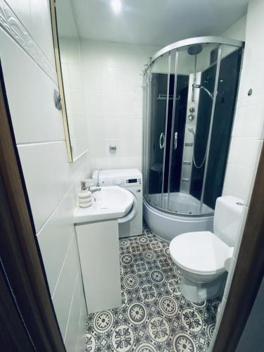 Baño blanco con lavabo y aseo en Apartament w centrum, en Płock