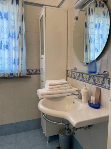 bagno con lavandino e specchio di Villa I Giardini del Conero con ombrellone in spiaggia a Porto Recanati
