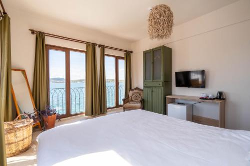 a bedroom with a bed and a view of the ocean at CasaLyma Ayvalık in Ayvalık