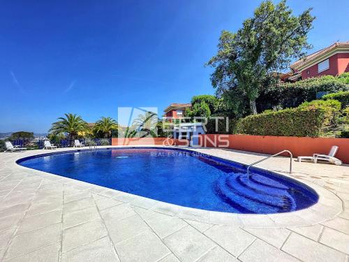 une piscine avec de l'eau bleue dans une cour dans l'établissement Superbe appartement 3 chambres avec vue panoramique, à Mandelieu-la-Napoule