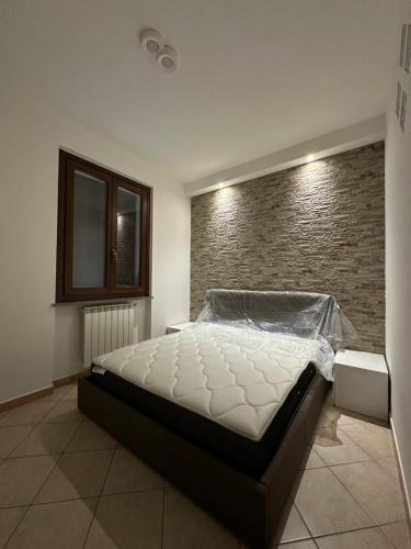 a bed in a room with a brick wall at la corte di seba milano malpensa in Cardano al Campo