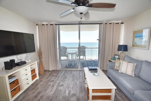 uma sala de estar com um sofá e uma televisão de ecrã plano em 0804 Waters Edge Resort condo em Myrtle Beach