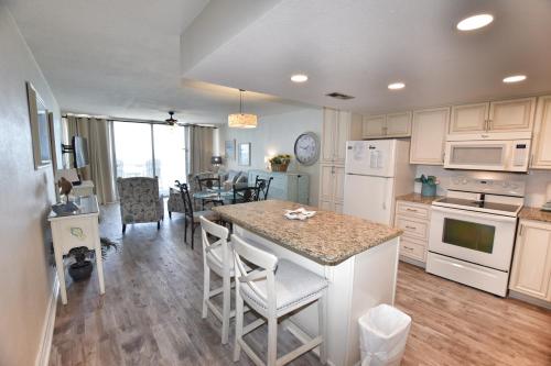 uma cozinha com electrodomésticos brancos e uma mesa com cadeiras em 0804 Waters Edge Resort condo em Myrtle Beach