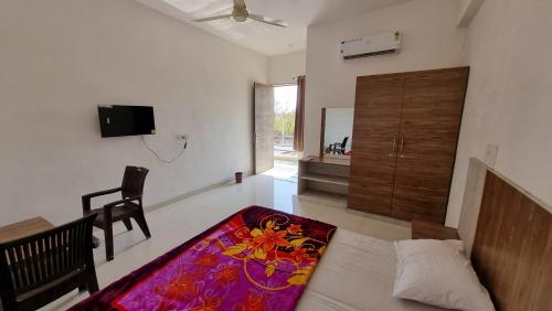 a living room with a bed and a chair and a rug at Hotel Mayur Inn in Udaipur