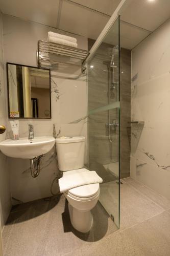 a bathroom with a toilet and a sink and a shower at Star Plaza Hotel in Dagupan