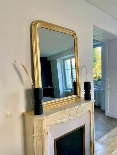 - un miroir au-dessus d'une cheminée dans la chambre dans l'établissement Chambre privée dans spacieuse maison de maître, à Cousancelles