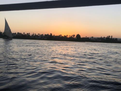 ein Segelboot auf dem Wasser bei Sonnenuntergang in der Unterkunft King of love in Luxor