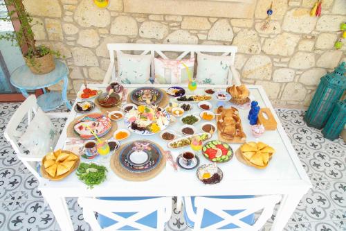 a white table with food and dishes on it at Alacatı Leylak Hotel in Alacati