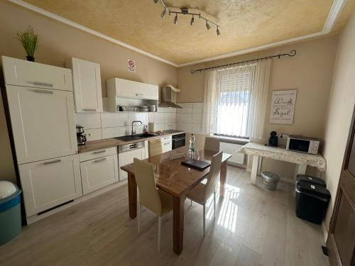 a kitchen with a wooden table and a dining room at Palminas Monteur FeWo EG in Merzig