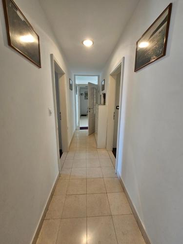 a hallway with white walls and a tile floor at Apartments at Villa Stegic in Tisno